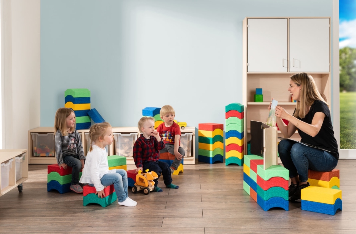 Kindern wird vorgelesen, die Bausteine als Hocker Kindern wird vorgelesen, die Bausteine als Hocker