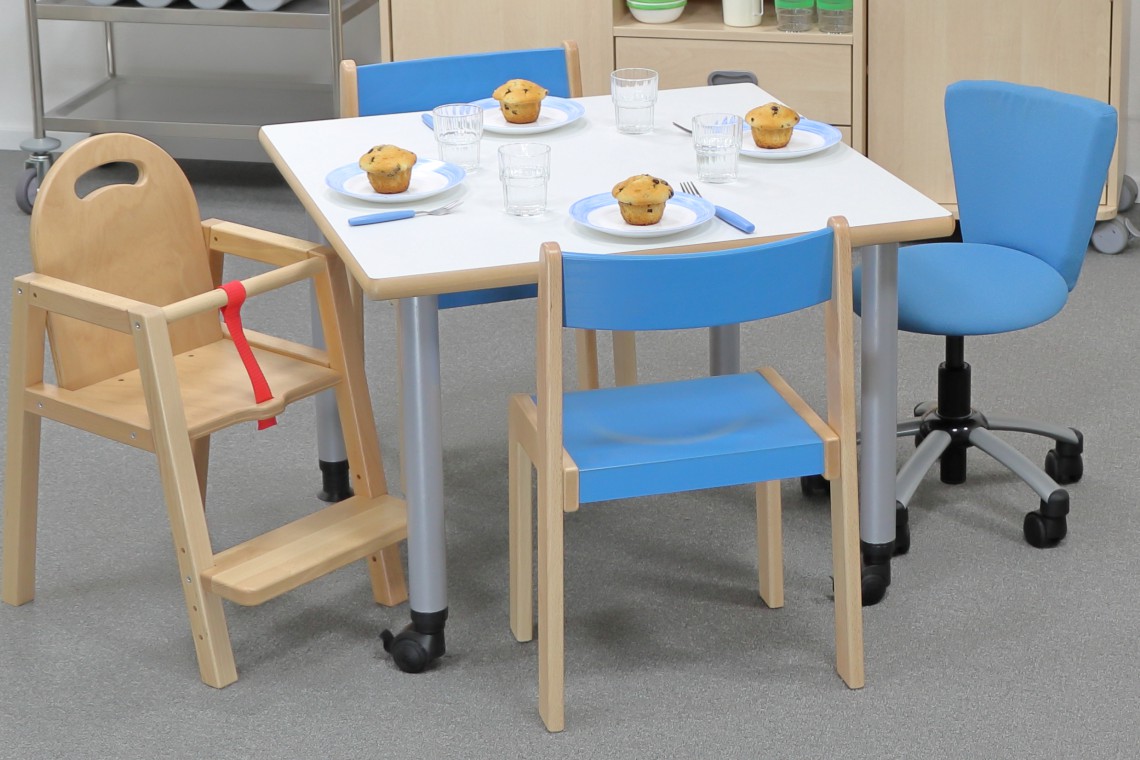 Höhenverstellbarer Tisch ohne Zarge mit Stühlen und Deko