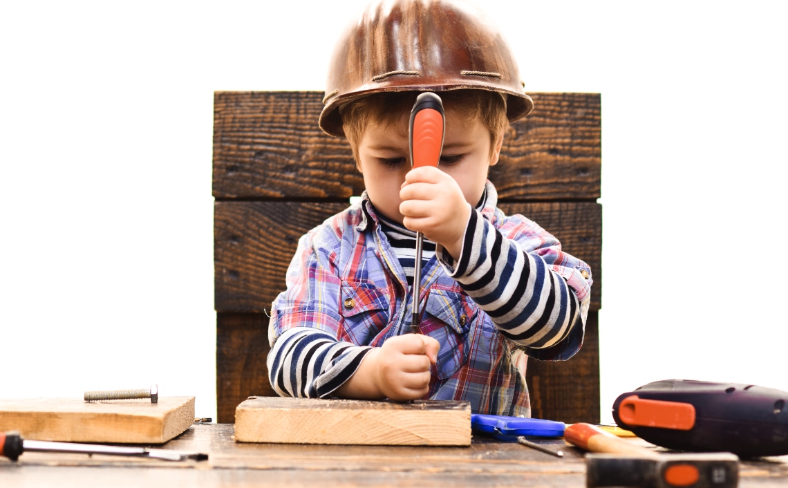 Kind mit Helm und Schraubendreher Kind mit Helm und Schraubendreher